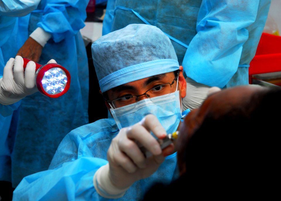 US Navy 100801-N-4044H-026 Singapore Military Force Capt. Desmond Ng, a dentist, performs a tooth extraction during a Sail Banda 2010 dental civic action program at Tulehu village in Ambon, Indonesia