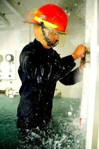 US Navy 100803-N-7498L-266 Coast Guard Machinery Technician 3rd Class Chris Warner performs a jubilee patch inside the flooding Surface Damage Control Trainer at the Center of Naval Engineering Learning Site Pearl Harbor