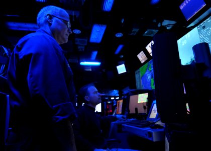 US Navy 100805-N-2013O-058 Chief Warrant Officer 2 James Cox rains Ensign Michael Denstedt to become a tactical action officer while manning the tactical action officer console in the combat direction center aboard USS George W