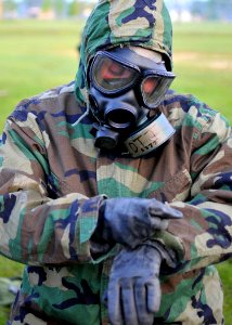 US Navy 100806-N-4440L-051 Equipment Operator Construction Apprentice Steven Lott dons his chemical, biological, radiological (CBR) gear during a mission oriented protective posture (MOPP) level 4 drill