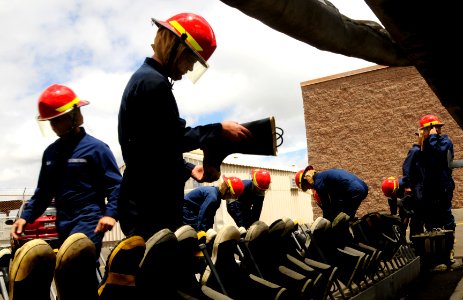 US Navy 100803-N-7498L-211 Coast Guard Fireman Jared Miller selects a pair of boots as he prepares to enter the Surface Damage Control Trainer at the Center of Naval Engineering Learning Site Pearl Harbor