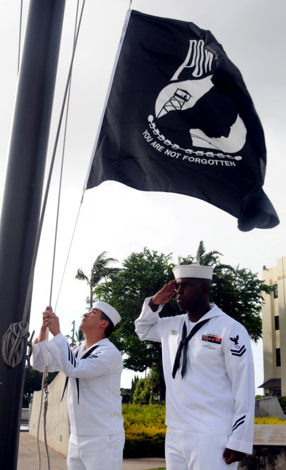 US Navy 100804-N-3666S-015 Culinary Specialist 1st Class Richard Cravens, left, and Operations Specialist 2nd Class James Darde raise the POW-MIA flag during morning colors