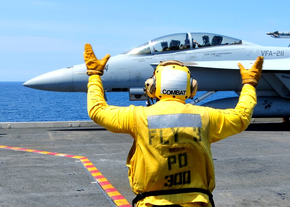 US Navy 100804-0569K-N-022 An aircraft director guides pilots assigned to the Checkmates of Strike Fighter Squadron (VFA) 211 into position aboard the aircraft carrier USS Enterprise (CVN 65)