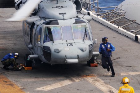 US Navy 100804-N-3852A-560 Aviation Boatswain's Mate (Handling) 3rd Class Kristy Downing, left, and Aviation Boatswain's Mate (Handling) Airman Eddie Berryhill chock and chain an MH-60S Sea Hawk search and rescue helicopter