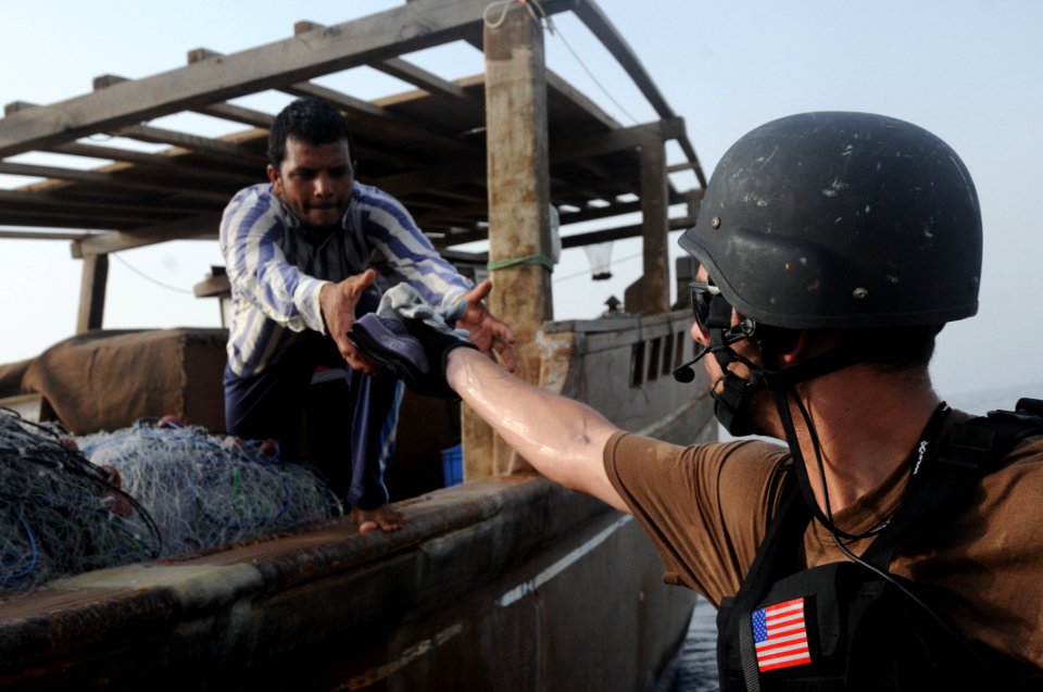 US Navy 100809-N-6463B-166 A Sailor hands supplies to a fisherman in the Red Sea