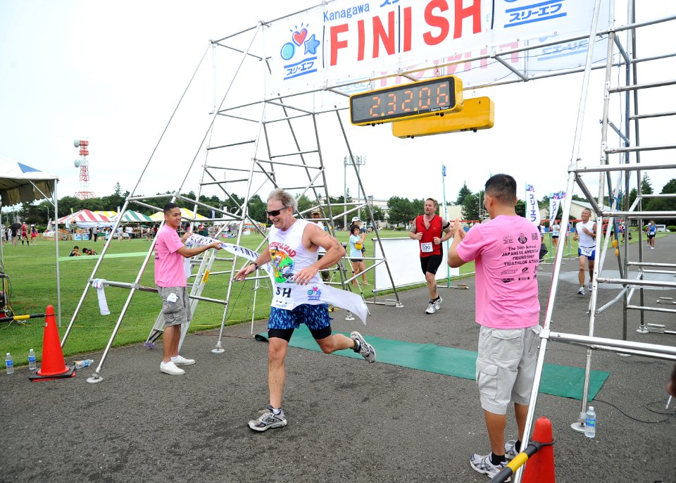 US Navy 100808-N-2858S-591 Capt. Eric Gardner, commanding officer of Naval Air Facility (NAF) Atsugi, crosses the finish line after completing the 24th Japanese American Friendship Triathlon at NAF Atsugi