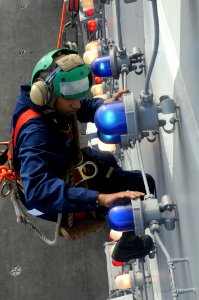 US Navy 100808-N-7605J-216 Electrician's Mate 3rd Class Brittany Davis replaces a blown light bulb on the island of USS Ronald Reagan (CVN 76)