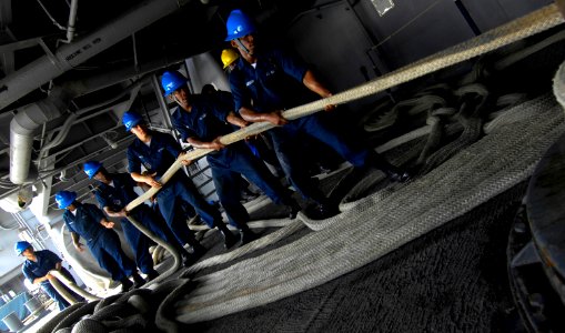 US Navy 100810-N-4135M-024 Sailors assigned to the deck department of the aircraft carrier USS Harry S. Truman (CVN 75), heave in a mooring line in preparation for the ship's departure