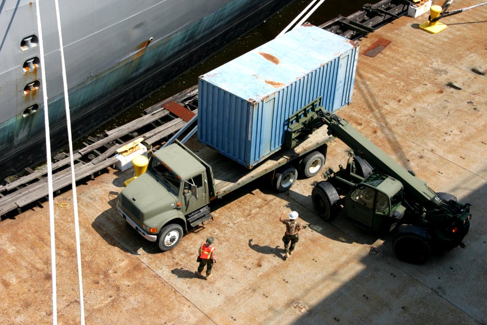 US Navy 100808-N-2888Q-005 Sailors transfer a container box lowered by crane from USNS Pomeroy (T-AKR 316) to a flatbed truck for transport