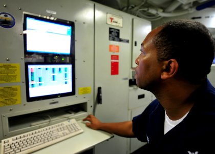 US Navy 100811-N-1287L-019 Aviation Electrician's Mate 2nd Class Daryl C. Latimer monitors a generator from an F-A-18F Super Hornet