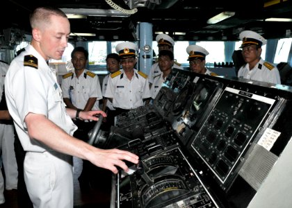 US Navy 100811-N-3215T-056 Lt. j.g. Brian Hamilton describes the functions of the helm aboard the guided-missile destroyer USS John S. McCain (DDG 56) to Vietnamese officers during a tour of the ship