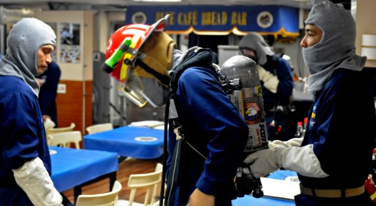 US Navy 100809-N-7280V-118 PACIFIC OCEAN (Aug. 9, 2010) Culinary Specialist 1st Class Neil Monato and Senior Chief Culinary Specialist Nelson San Pedro check a Sailor's self contained breathing apparatus during an engine room