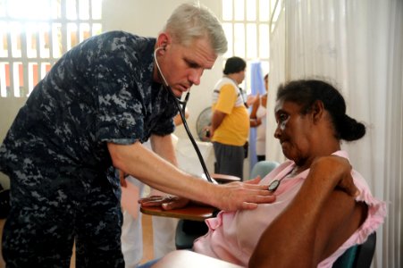 US Navy 100809-N-9964S-177 Cmdr. Timothy Burgess, embarked aboard the multipurpose amphibious assault ship USS Iwo Jima (LHD 7), conducts medical examinations during a Continuing Promise 2010 medical community service event photo