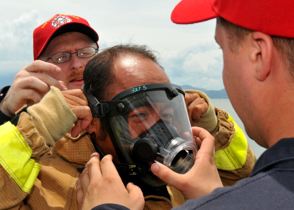 US Navy 100812-N-3215T-134 Sailors assigned to the guided-missile destroyer USS John S. McCain (DDG 56) help a Vietnam People's Navy sailor put on a firefighting facemask during a damage control demonstration