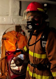 US Navy 100810-N-1287L-105 An emergency responder uses an explosion-proof box fan to clear smoke in a compartment during a general quarters exercise aboard USS Enterprise (CVN 65)