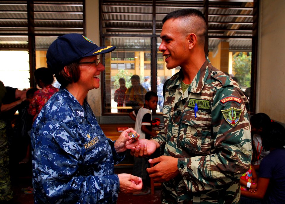 US Navy 100812-N-4044H-242 Capt. Lisa M. Franchetti, commander of Pacific Partnership 2010, presents a coin to a Timorese military policeman during her visit to a Pacific Partnership medical civic action program event in Dili,
