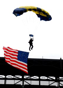 US Navy 100810-N-5366K-213 Aircrew Survival Equipmentman 1st Class Thomas Kinn, assigned to the U.S. Navy parachute demonstration team, the Leap Frogs, makes his final approach to land with an American flag photo