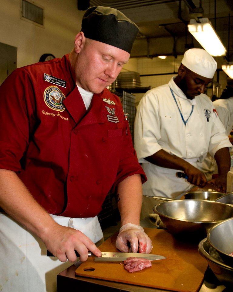 US Navy 100813-N-2389S-048 Culinary Specialist 1st Class Matthew Susienka prepares veal during the Le Cordon Bleu cooking competition as part of Chicago Navy Week