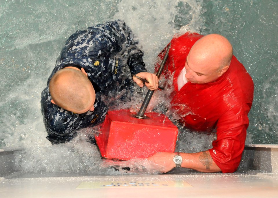 US Navy 100812-N-3283P-009 Chief Damage Controlman Matt Walz nd Master Chief Damage Controlman David Singer demonstrate how to apply a box patch to a ruptured bulkhead to Japanese college students