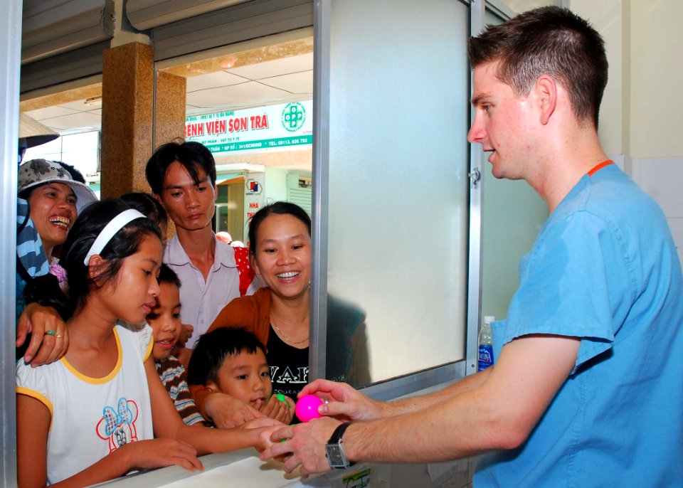 US Navy 100811-N-3589B-051 Hospital Corpsman 2nd Class Joseph Smith, assigned to the guided-missile destroyer USS John S. McCain (DDG 56), hands out toys to patients while filling prescriptions during a medical civic action pro