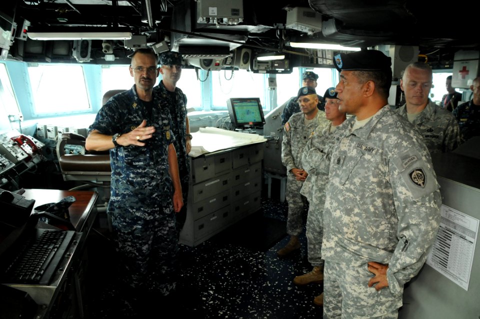 US Navy 100813-N-3283P-016 Command Master Chief Eric Cole, left, describes the duties and responsibilities of the bridge watch team to Command Sgt. Maj. Luniasolua Savusa, right,