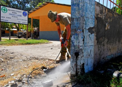 US Navy 100813-N-4044H-123 Royal Australian Engineer Sapper David Kober pressure washes a wall before painting during a Pacific Partnership engineering civic action program event at Nu Laran School in Dili
