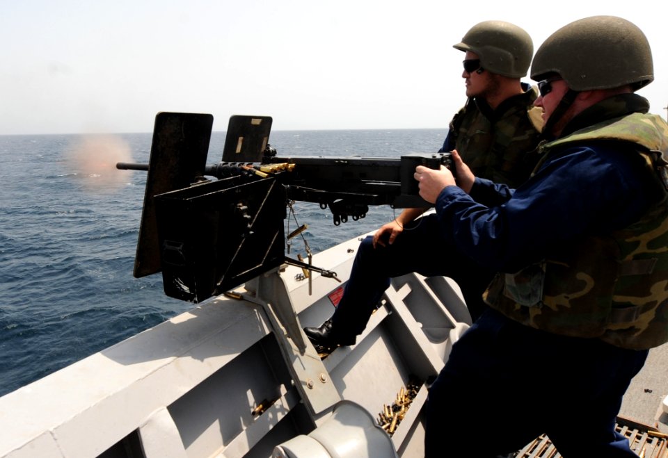 US Navy 100811-N-6463B-487 Gunner's Mate 2nd Class Rosenburg Castano, left, oversees Navy Counselor 2nd Class Ronnie Lindsey during a .50-caliber machine gun weapons training exercise