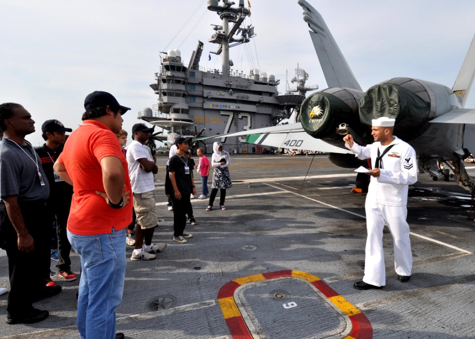 US Navy 100814-N-2013O-092 Mass Communication Specialist 2nd Class Carlos Gomez explains the functions of the tail hook on an F-A-18C Hornet