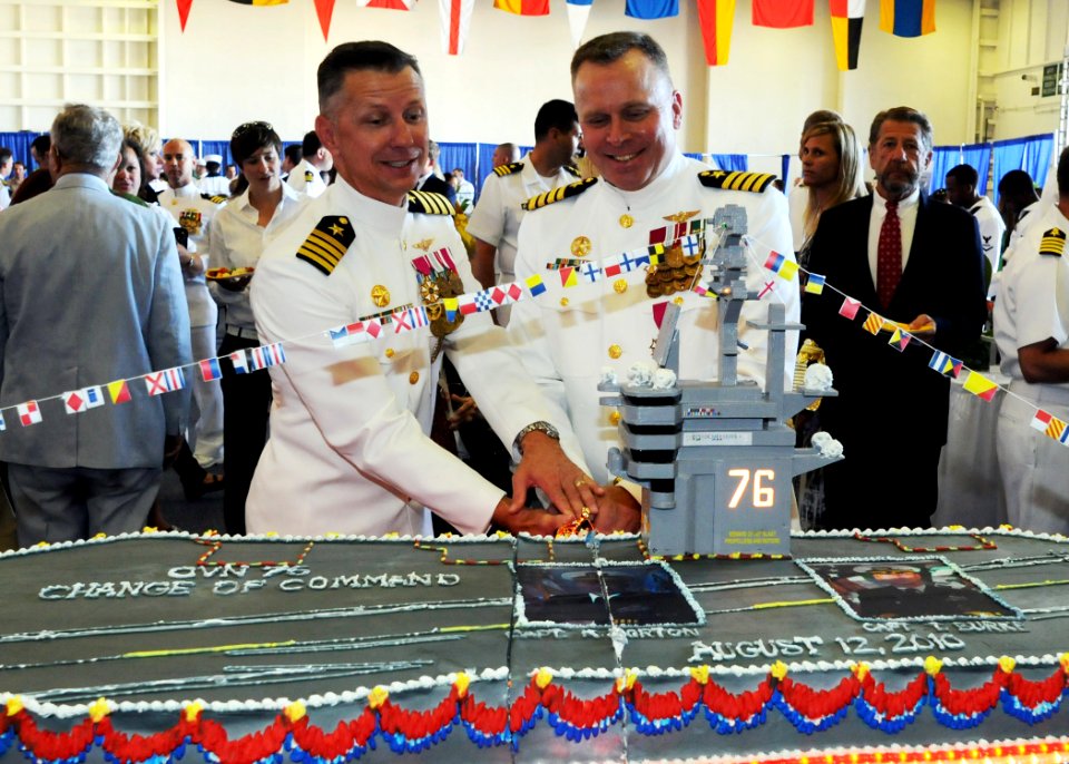 US Navy 100812-N-1004S-517 Capt. Thom W. Burke, left, and Capt. Kenneth J. Norton cut into a cake modeled after the aircraft carrier USS Ronald Reagan (CVN 76) during a reception following their change of command ceremony