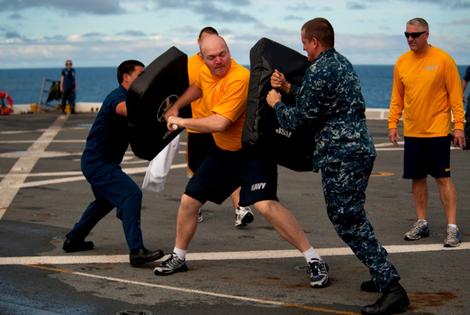 US Navy 100814-N-5319A-014 Operations Specialist 2nd Class Jack Boll defends against simulated attackers after being sprayed with oleoresin capsicum