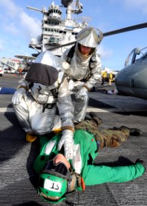 US Navy 100813-N-1287L-037 Members of the crash and salvage team check a Sailor for injuries during a mass casualty exercise on the flight deck of USS Enterprise (CVN 65)