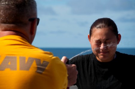 US Navy 100814-N-5319A-078 Chief Gunner's Mate Robert DelaMontaigne sprays Aviation Boatswain's Mate (Fuels) Airman Karina Allain with oleoresin capsicum