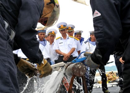 US Navy 100812-N-3215T-313 Vietnam People's Navy sailors watch as Sailors assigned to the guided-missile destroyer USS John S. McCain (DDG 56) demonstrate how to patch a leaking pipe during a damage control demonstration aboard
