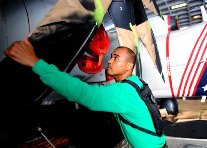 US Navy 100816-N-1287L-011 Aviation Structural Mechanic 3rd Class Robert Gonday prepares to paint the propeller tips of an E-2C Hawkeye