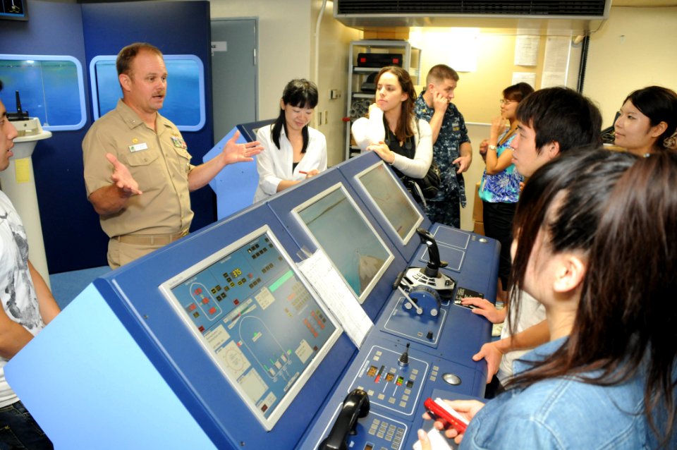US Navy 100812-N-3283P-010 Capt. Curtis J. Gilbert, commanding officer of Afloat Training Group Western Pacific (ATGWP), explains to Japanese college students the purpose of the navigation simulator during a tour of the command