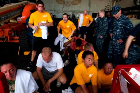 US Navy 100814-N-5319A-125 Sailors aboard the amphibious transport dock ship USS New Orleans (LPD 18) sit in front of fans to cool their faces after participating in oleoresin capsicum (OC) qualifications photo