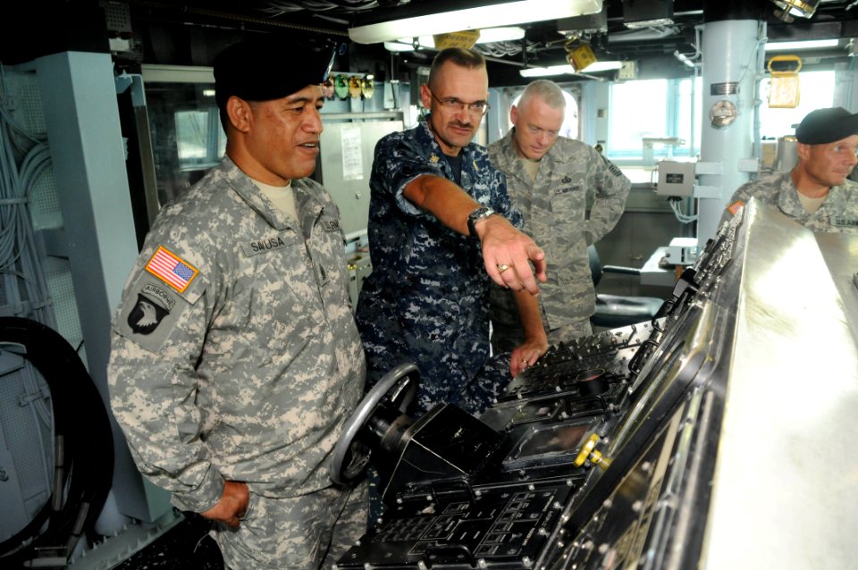 US Navy 100813-N-3283P-023 Command Master Chief Eric Cole, center, describes the capabilities of the navigation system aboard the guided-missile destroyer USS Fitzgerald (DDG 62)