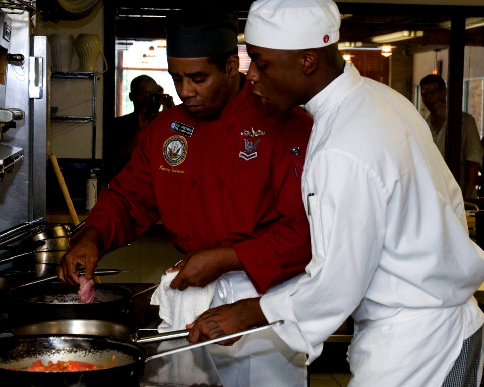 US Navy 100813-N-2389S-042 Culinary Specialist 2nd Class Juan Carethers work with a Le Cordon Bleu student during the Le Cordon Bleu cooking competition as part of Chicago Navy Week