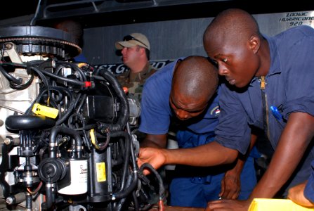 US Navy 100817-N-4971L-027 Members of the Royal Barbados Defense Force disassemble a small boat engine during a maintenance management subject matter expert exchange
