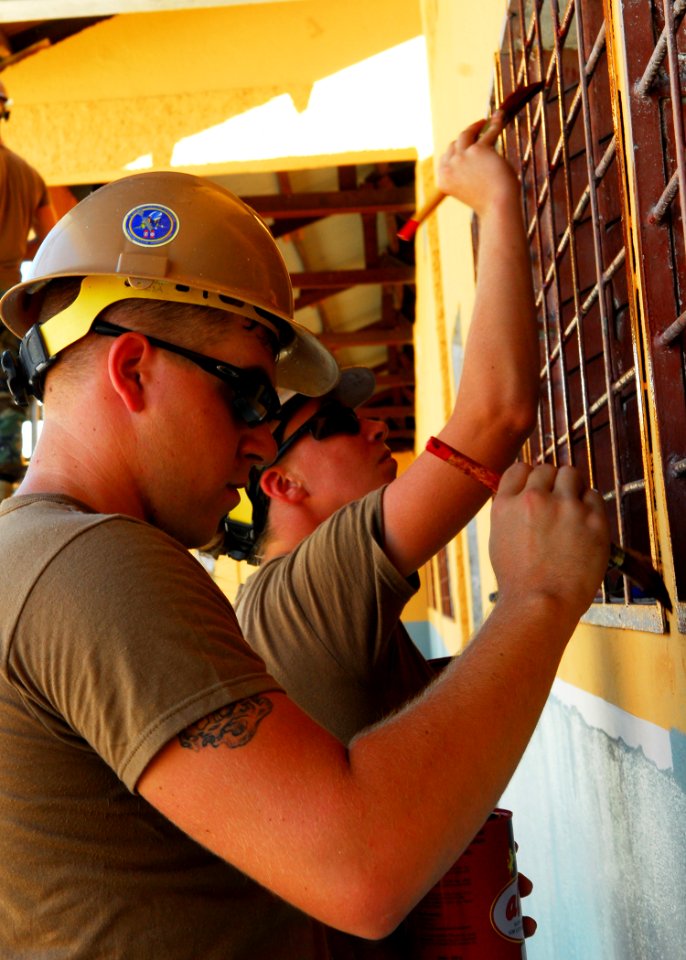 US Navy 100813-N-4044H-076 Seabees assigned to Naval Mobile Construction Battalion (NMCB) 11, paint window guards during a Pacific Partnership