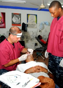 US Navy 100814-N-3265K-013 Cmdr. Scott Thomas, a dental officer, and Hospitalman Rashad Thompson, both assigned to the multi-purpose amphibious assault ship USS Iwo Jima (LHD 7)