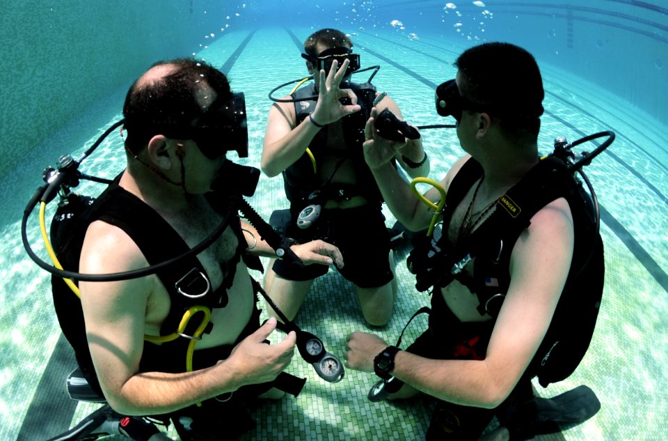 US Navy 100817-N-9769P-062 Navy Diver 2nd Class David Orme checks the status of Colombian divers, Capt. Camilo Cifuentez, right, and Chief Technician Aurelio Alonso, during underwater gear familiarization
