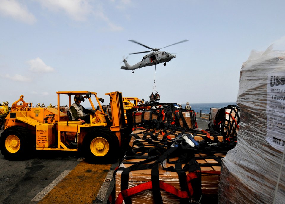 US Navy 100814-N-1226D-428 Lance Cpl. Michael Wertman moves cargo on the flight deck of USS Peleliu (LHA 5) during a vertical replenishment