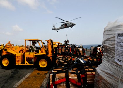 US Navy 100814-N-1226D-428 Lance Cpl. Michael Wertman moves cargo on the flight deck of USS Peleliu (LHA 5) during a vertical replenishment