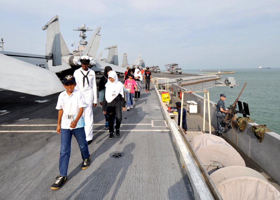 US Navy 100814-N-2013O-099 Boatswain's Mate Seaman Latonya Townes, from Orlando, Fla., guides children and staff of the Jamiyah Children's Home across the flight deck of the aircraft carrier USS George Washington (CVN 73)