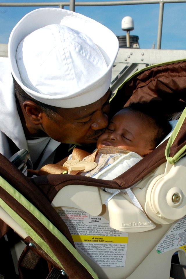 US Navy 100817-N-5292M-942 Naval Career Counselor 1st Class Osman Kamara kisses his six-week-old son goodbye before boarding USS Laboon (DDG 58)