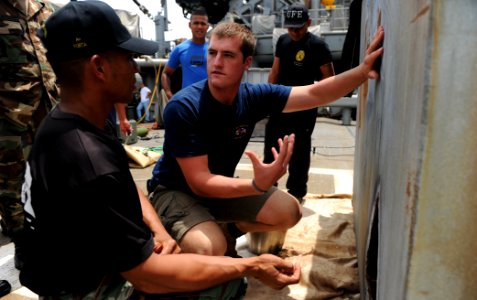 US Navy 100816-N-9769P-034 Navy Diver 2nd Class David Orme explains the procedures for cutting steel objects underwater to a Panamanian diver