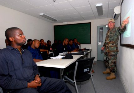 US Navy 100819-N-4971L-009 Equipment Operator 2nd Class Jeremy Hall discusses fiber glass repair procedures with Barbados Defense Forces during a subject matter expert exchange in Bridgetown, Barbados