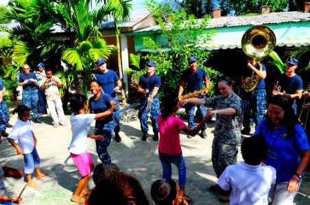 US Navy 100818-N-6410J-033 Sailors embarked aboard the Military Sealift Command hospital ship USNS Mercy (T-AH 19) dance with children at the Santa Bakhita Orphanage during a community service event photo