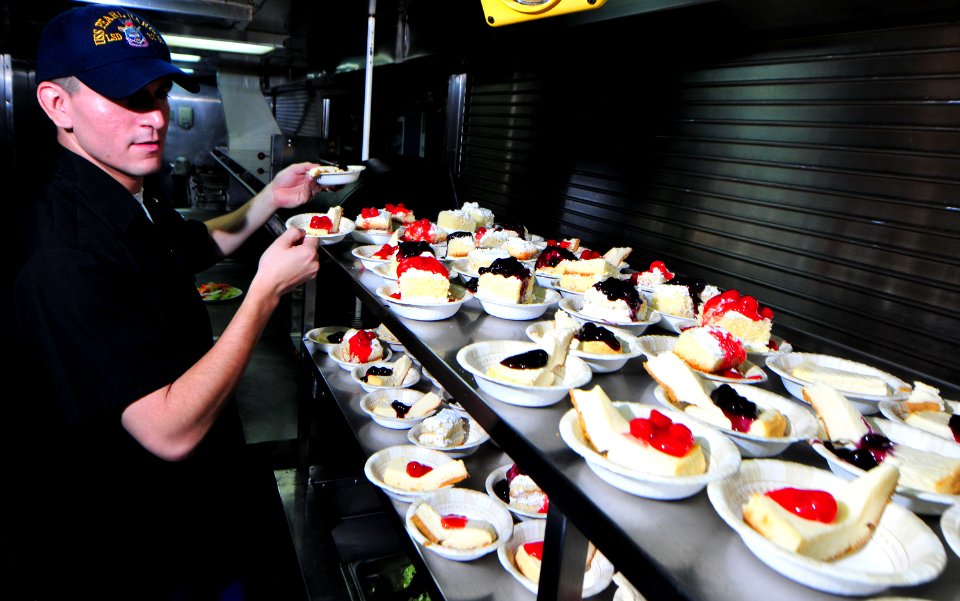 US Navy 100819-N-7948R-048 ulinary Specialist Seaman Fernando Chavez places cheese cakes on the serving line before lunch aboard USS Pearl Harbor (LSD 52)